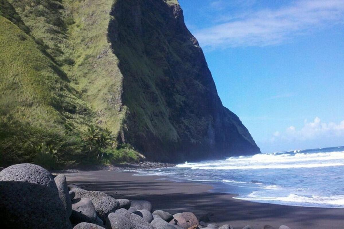 pantai berbatu dengan gunung besar di sebelah lautan
