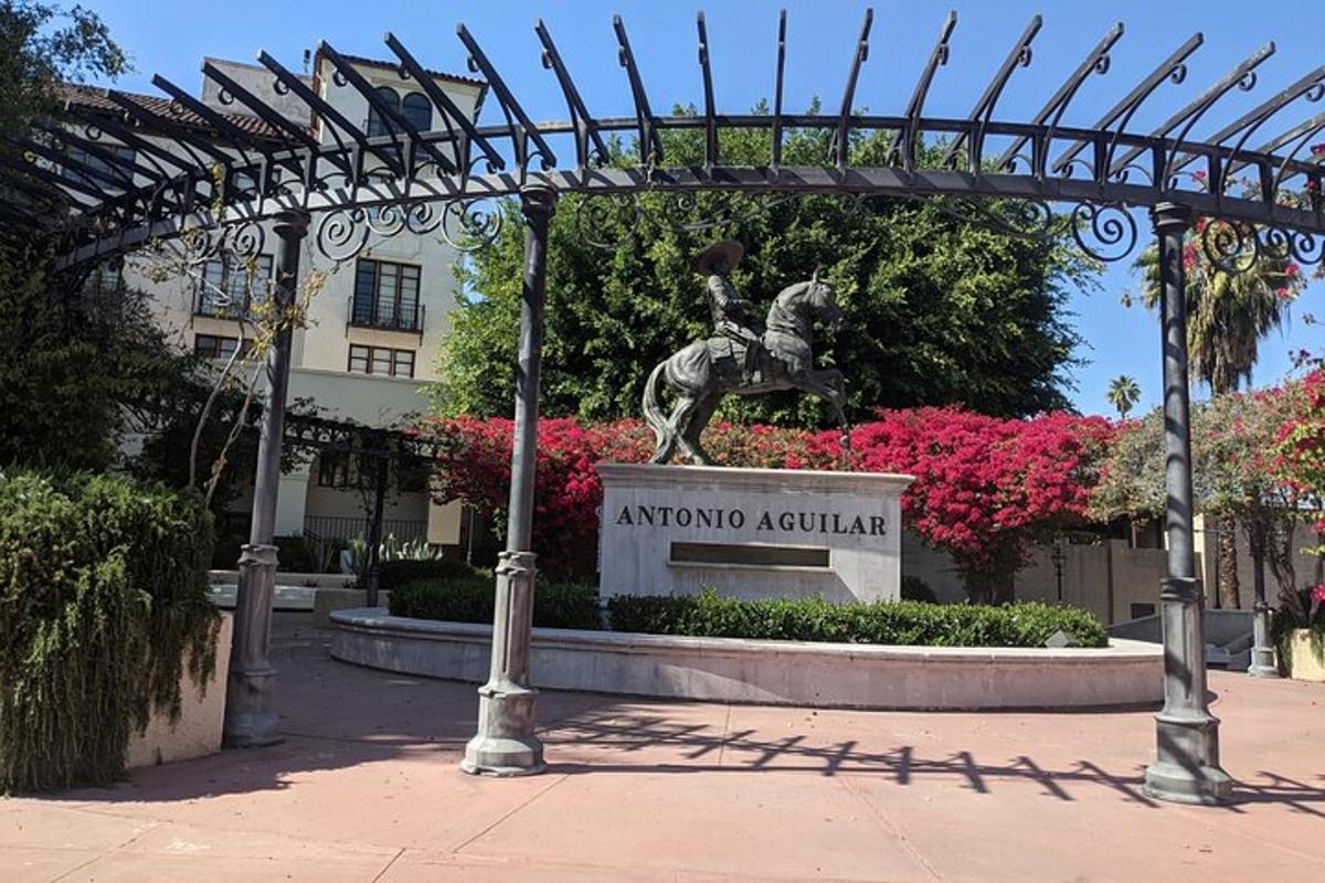 una statua di una donna a cavallo sotto un pergolato