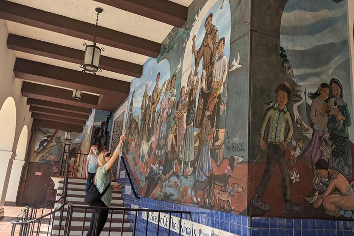 una donna è in piedi davanti a un murale su un muro