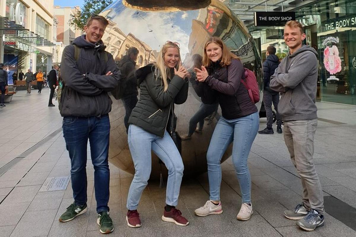 un gruppo di persone in piedi davanti a un cartello