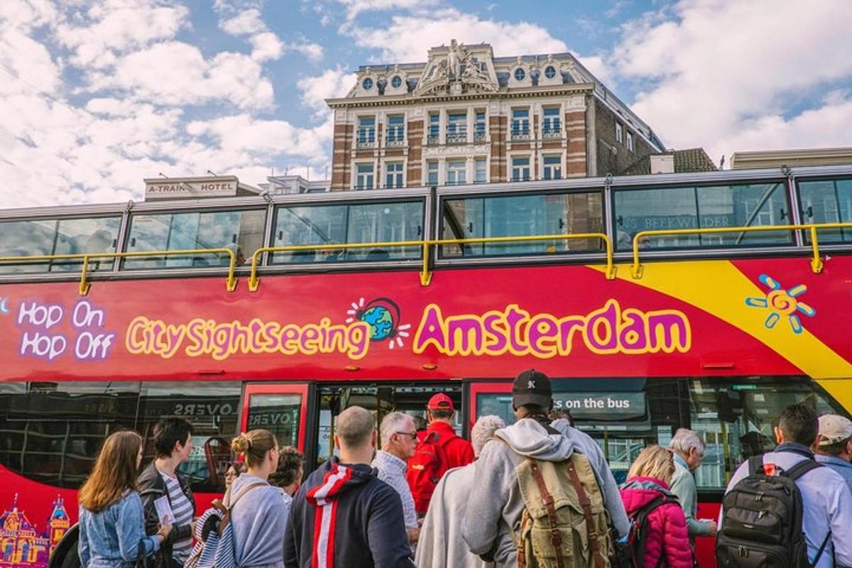 červený dvoupatrový autobus s davem lidí