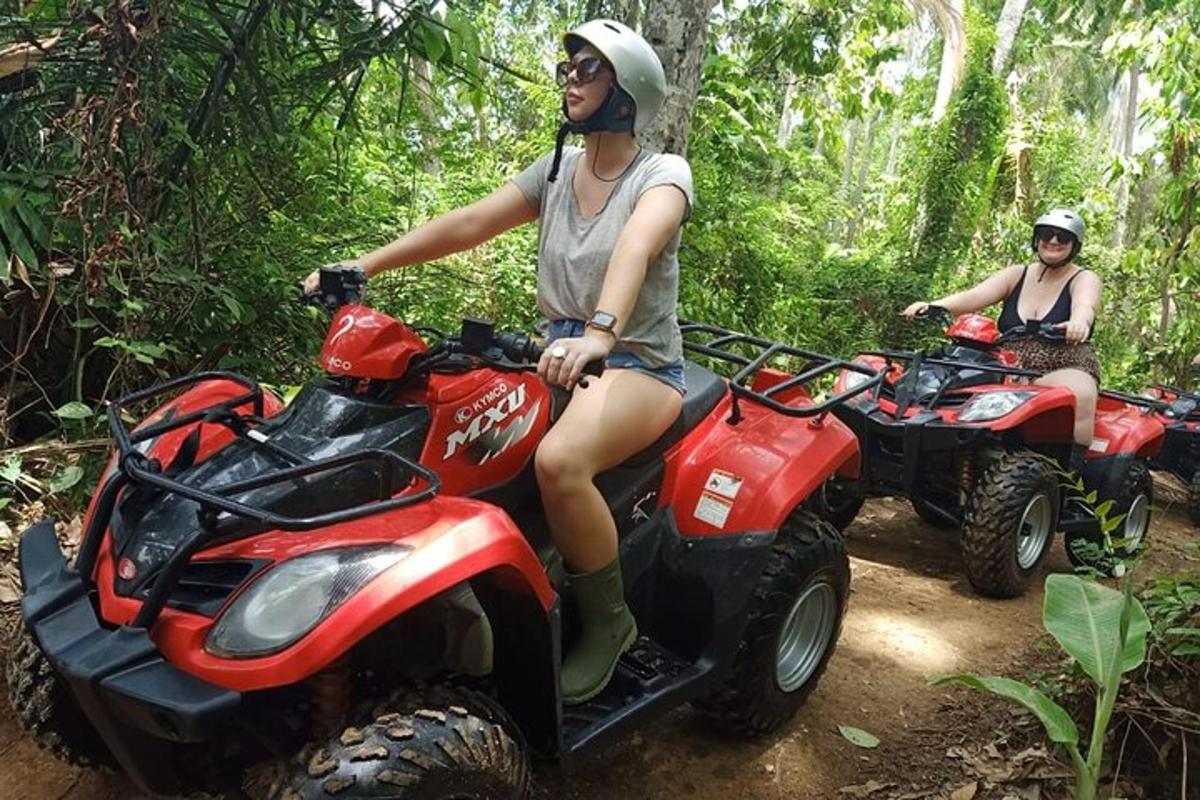duas pessoas andando de quadriciclo na floresta
