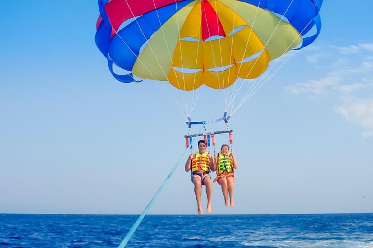 Dos personas están volando en paracaídas sobre el océano.