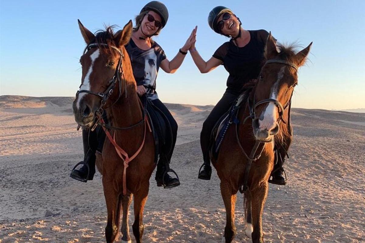dues dones muntant a cavall al desert