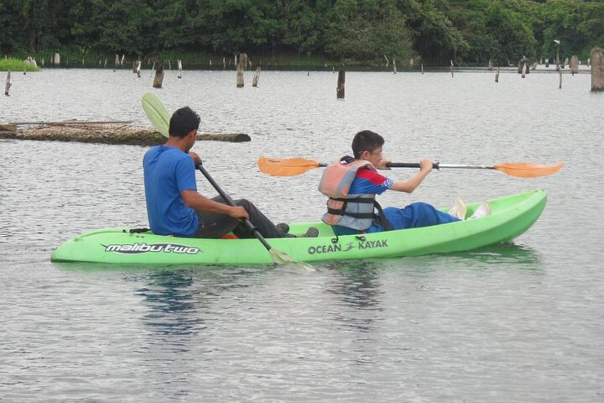 Dos hombres en un kayak verde en el agua
