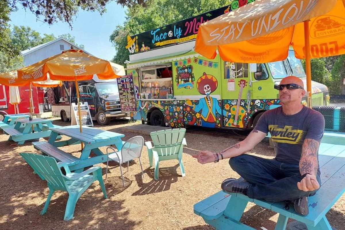 a man sitting on a bench in front of an ice cream truck