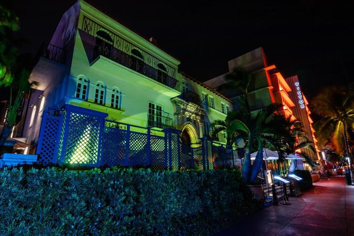 una casa blanca con una valla azul delante de un edificio