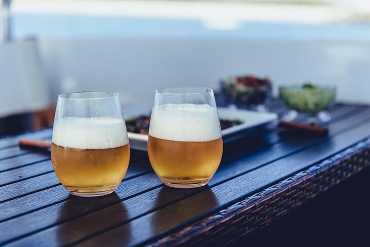 to glass øl som sitter på et trebord