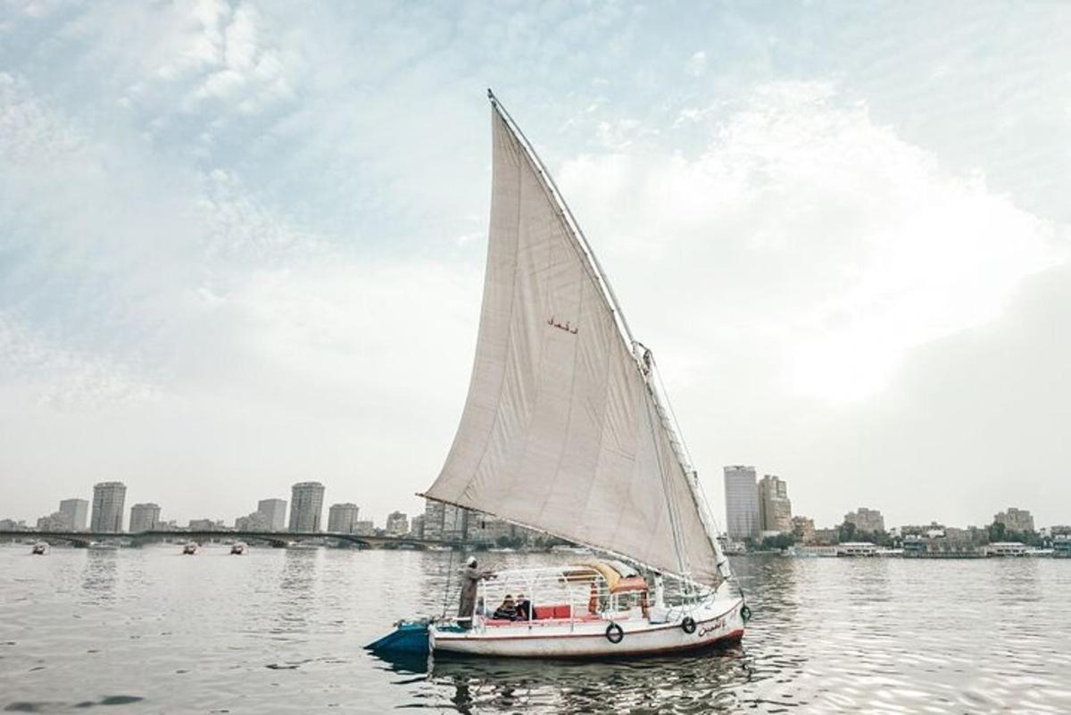 a sailboat on the water with a city in the background
