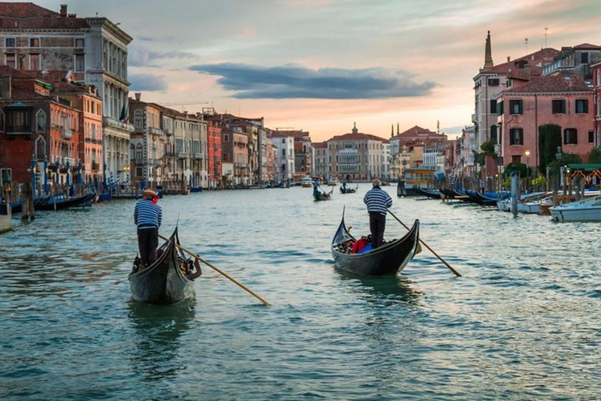 two people in gondolas on a canal in a city