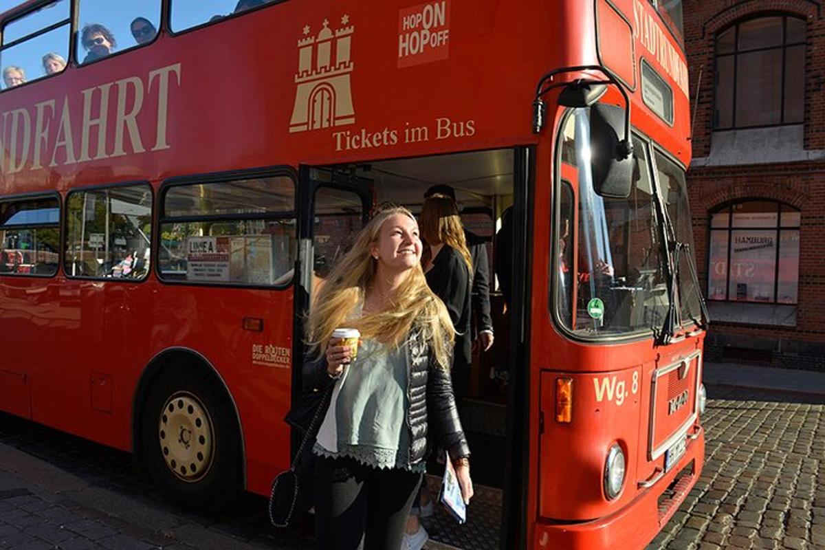 egy nő kiszáll egy piros emeletes buszból
