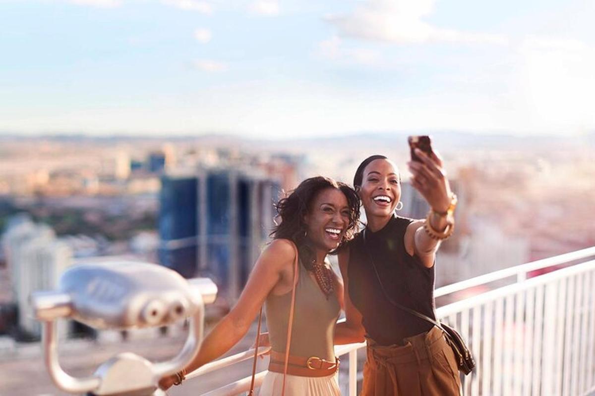 two women taking a picture on top of a building