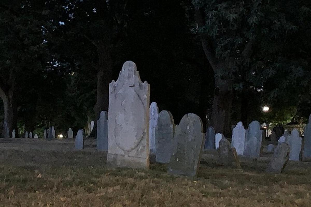 um grupo de lápides em um cemitério à noite