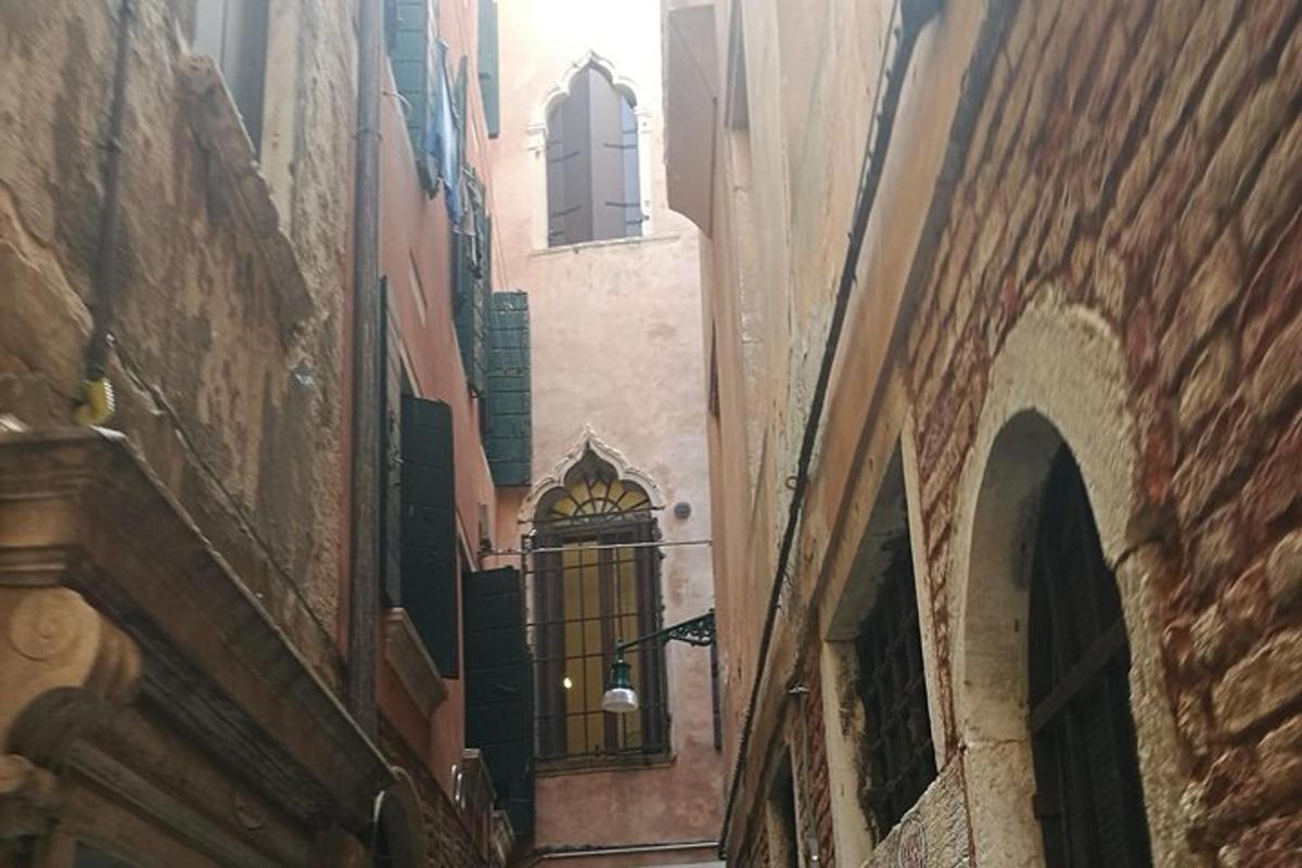 Un callejón entre dos edificios con una ventana.