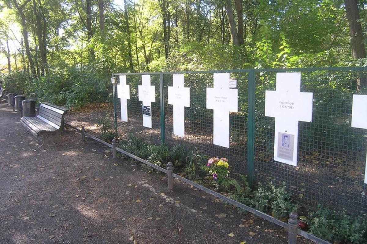 park se cedulemi na plotě a lavičkou