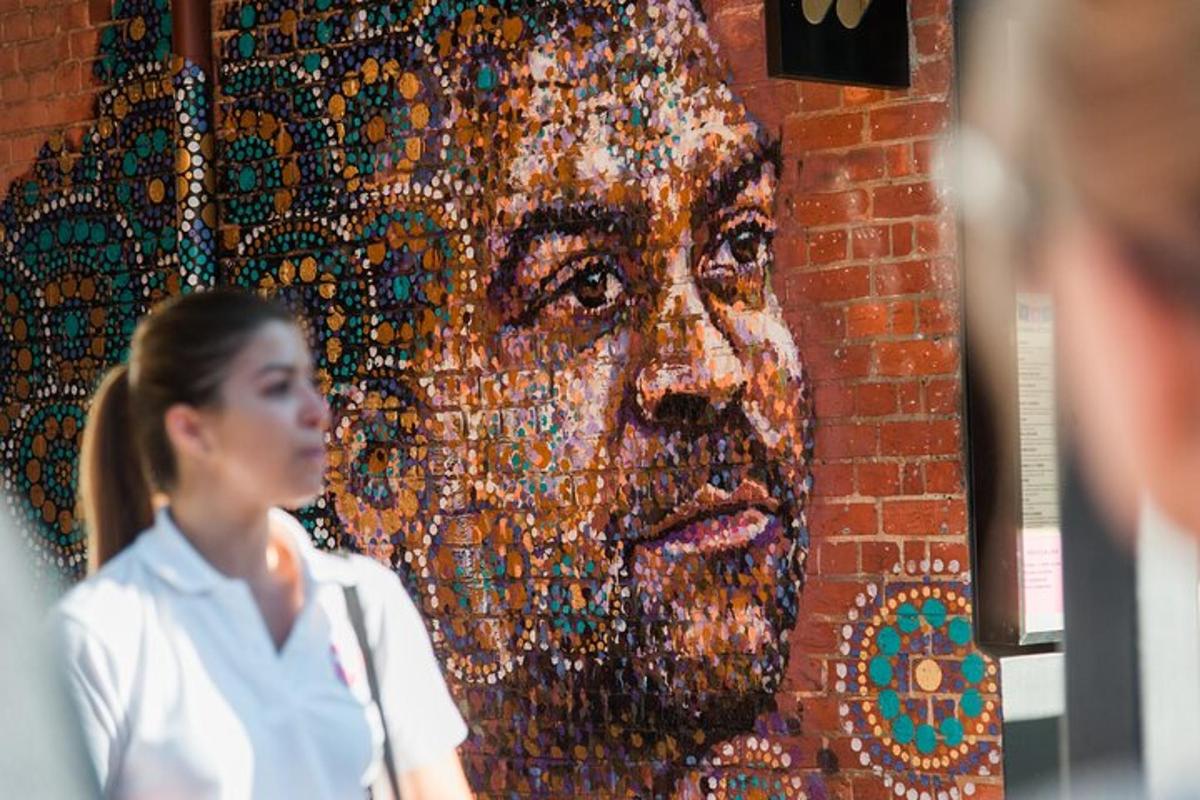 a woman standing in front of a mosaic portrait of a woman