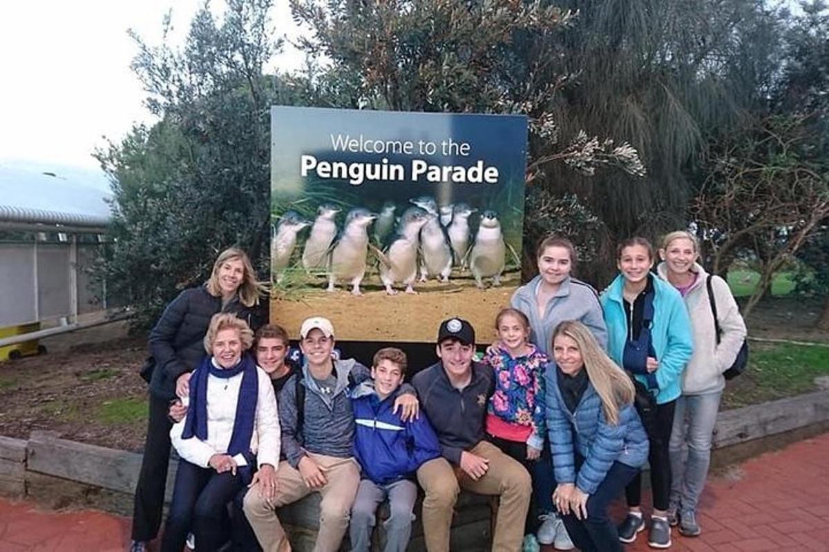 Un grupo de personas posando para una foto delante de un cartel.