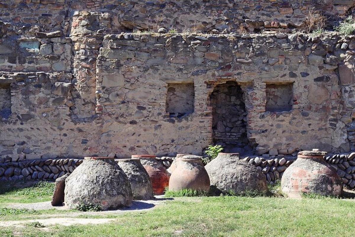 un gruppo di barattoli appoggiati accanto a un muro di pietra