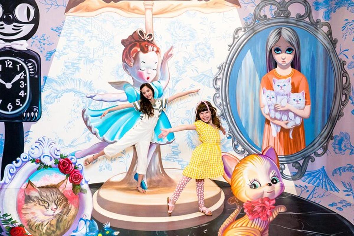 two girls are standing in front of a picture of a room with a mirror