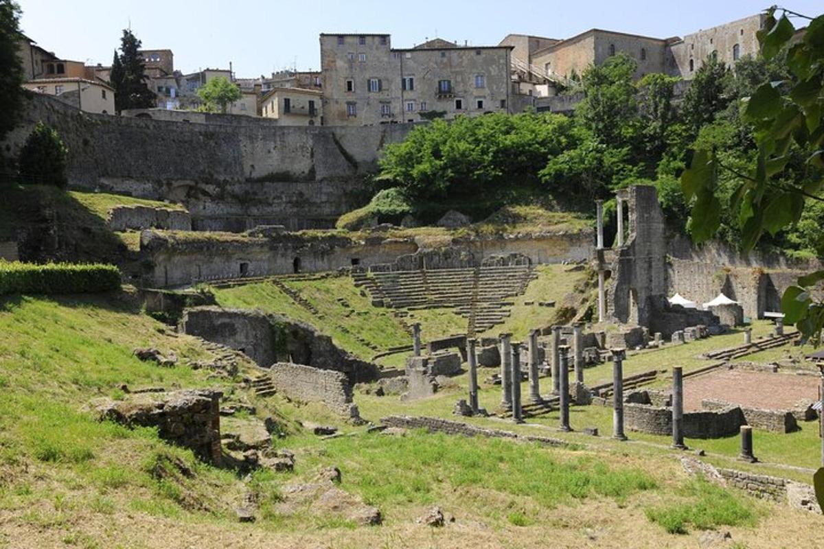 an ancient amphitheater with buildings in the background