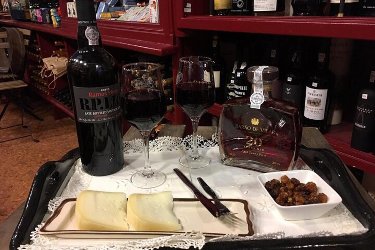 o tavă cu brânzeturi, vin și pahare pe o masă
