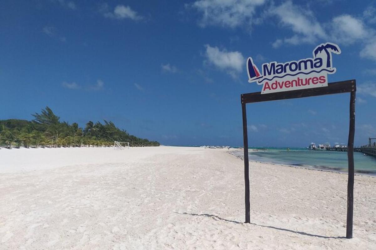a sign on a sandy beach with the ocean