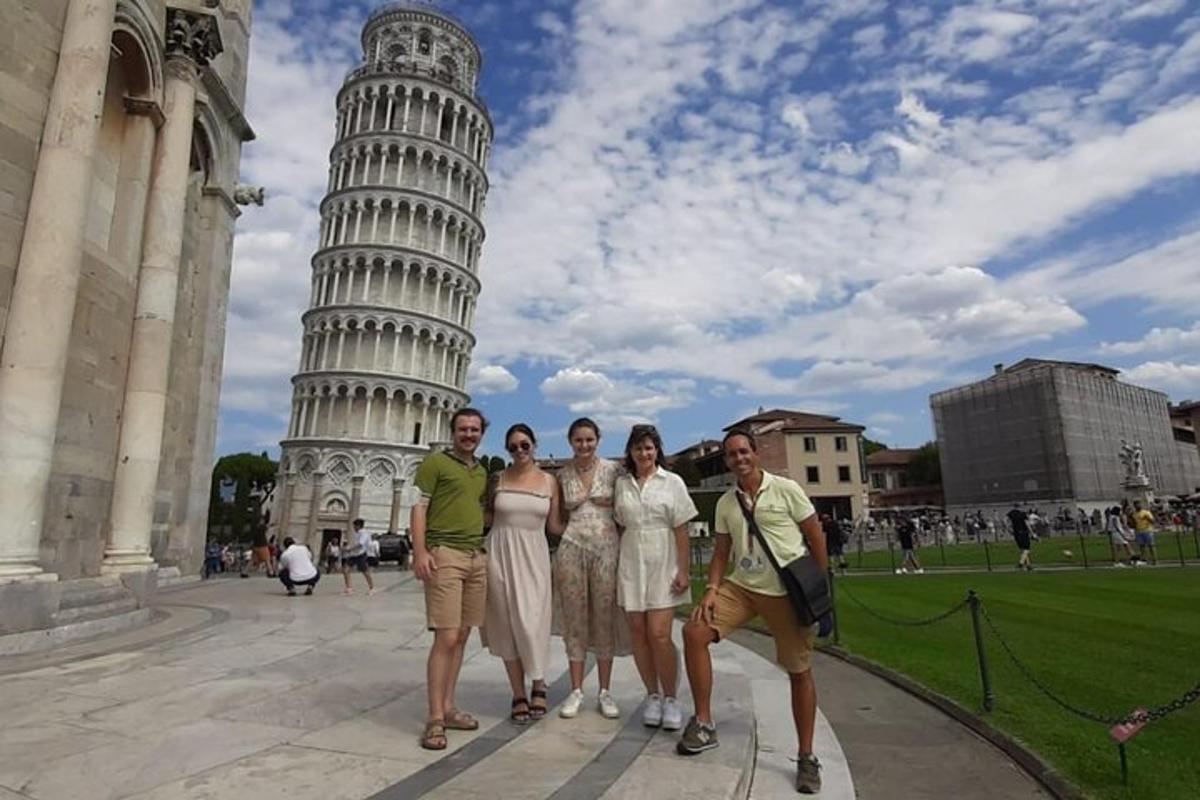 un gruppo di persone in piedi davanti alla torre pendente