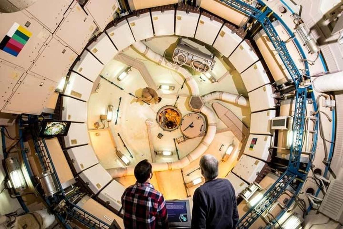 two men looking at a clock in a science museum