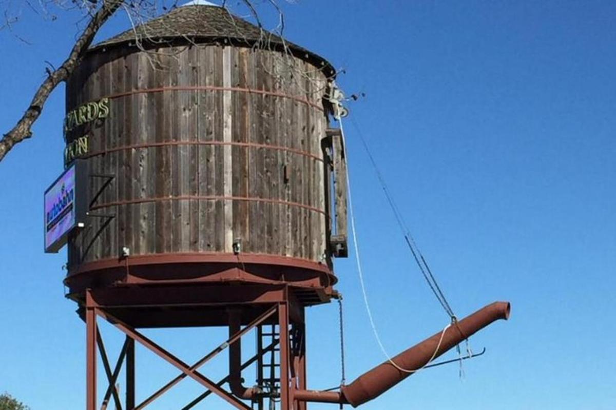 an old water tower sitting on top of a pole