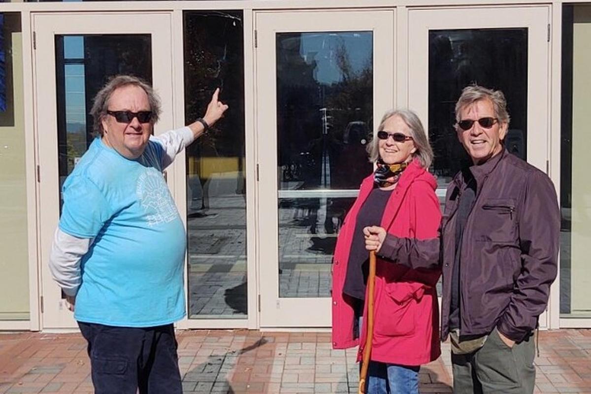 a group of three people standing in front of doors