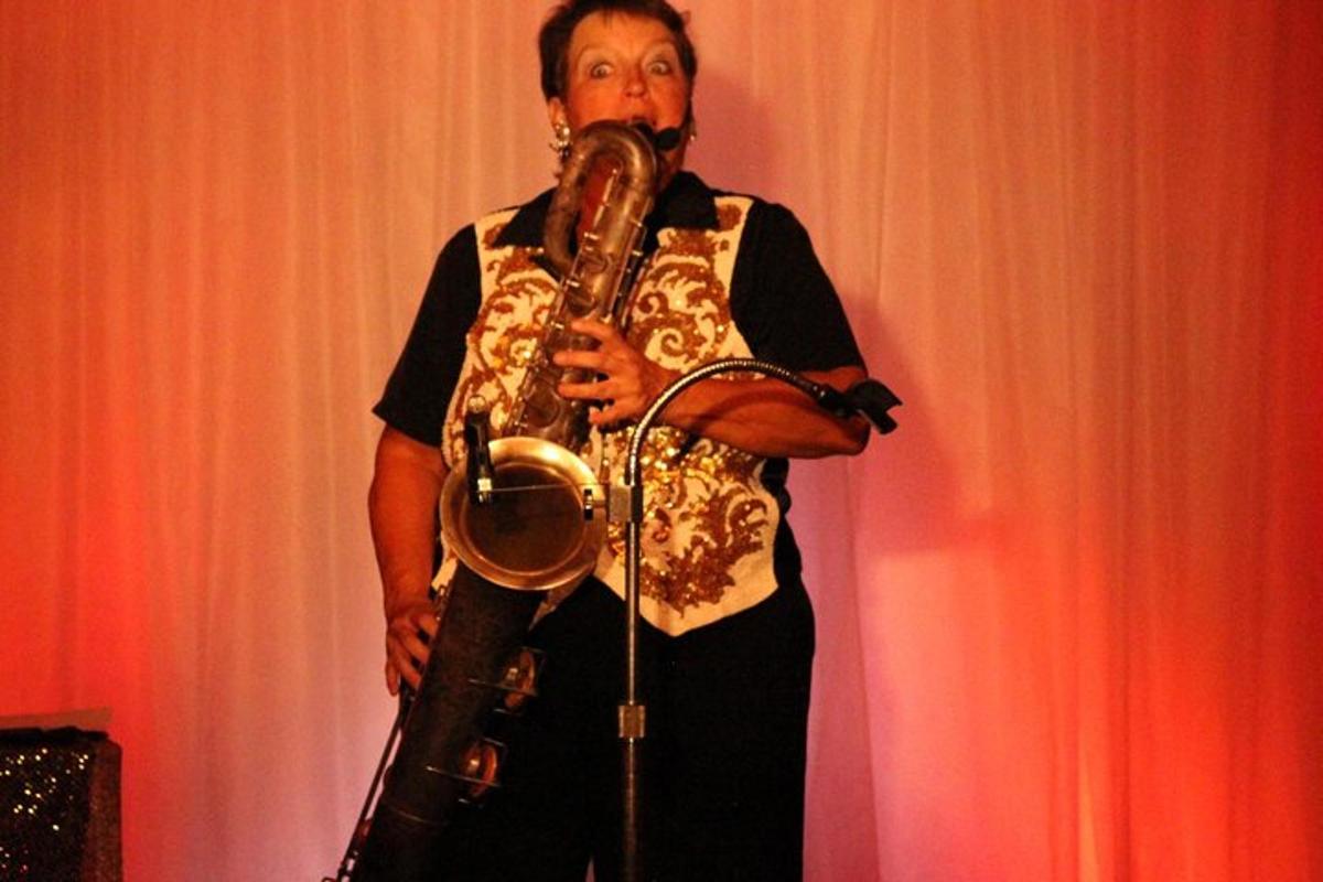 muž drží saxofon