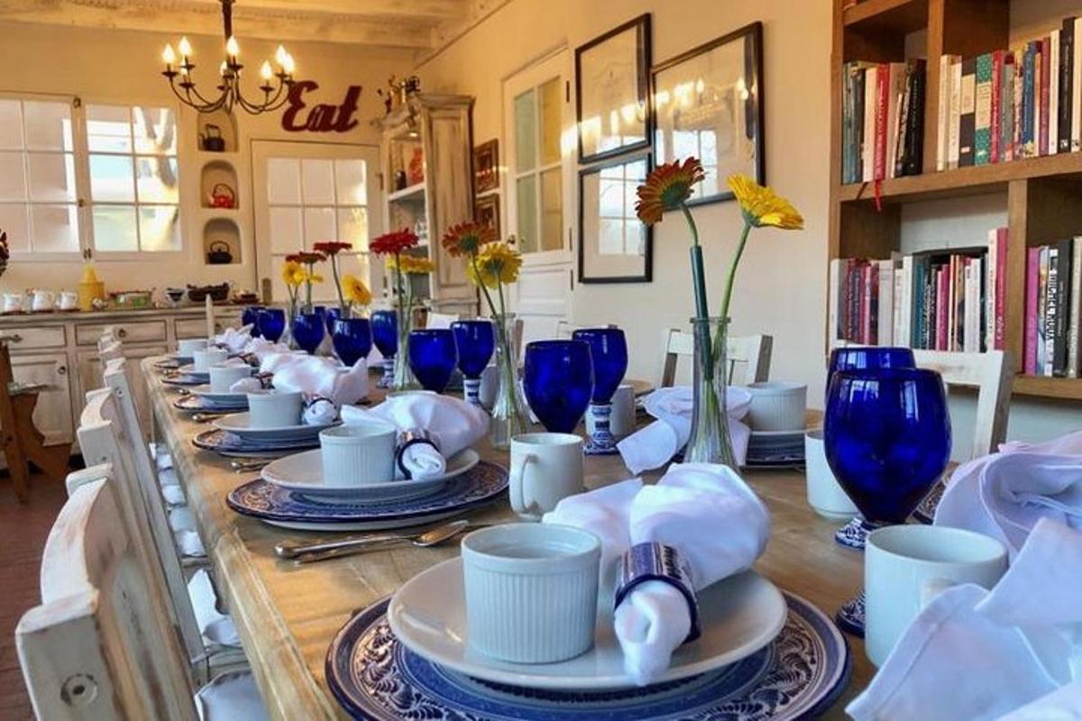 a long wooden table with blue glasses and plates on it