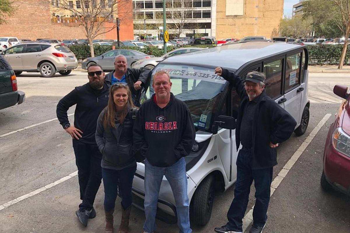 a group of people standing next to a car