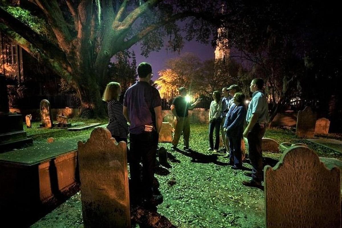 a group of people standing in a cemetery at night