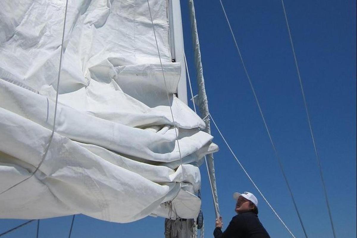 a man standing on the side of a sail on a boat