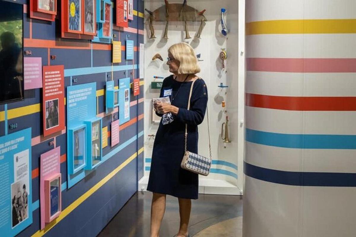 a woman standing in a hallway looking at a wall