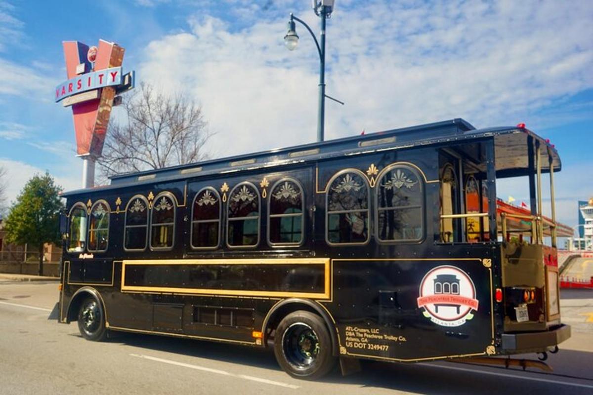 a black bus driving down a street with a sign