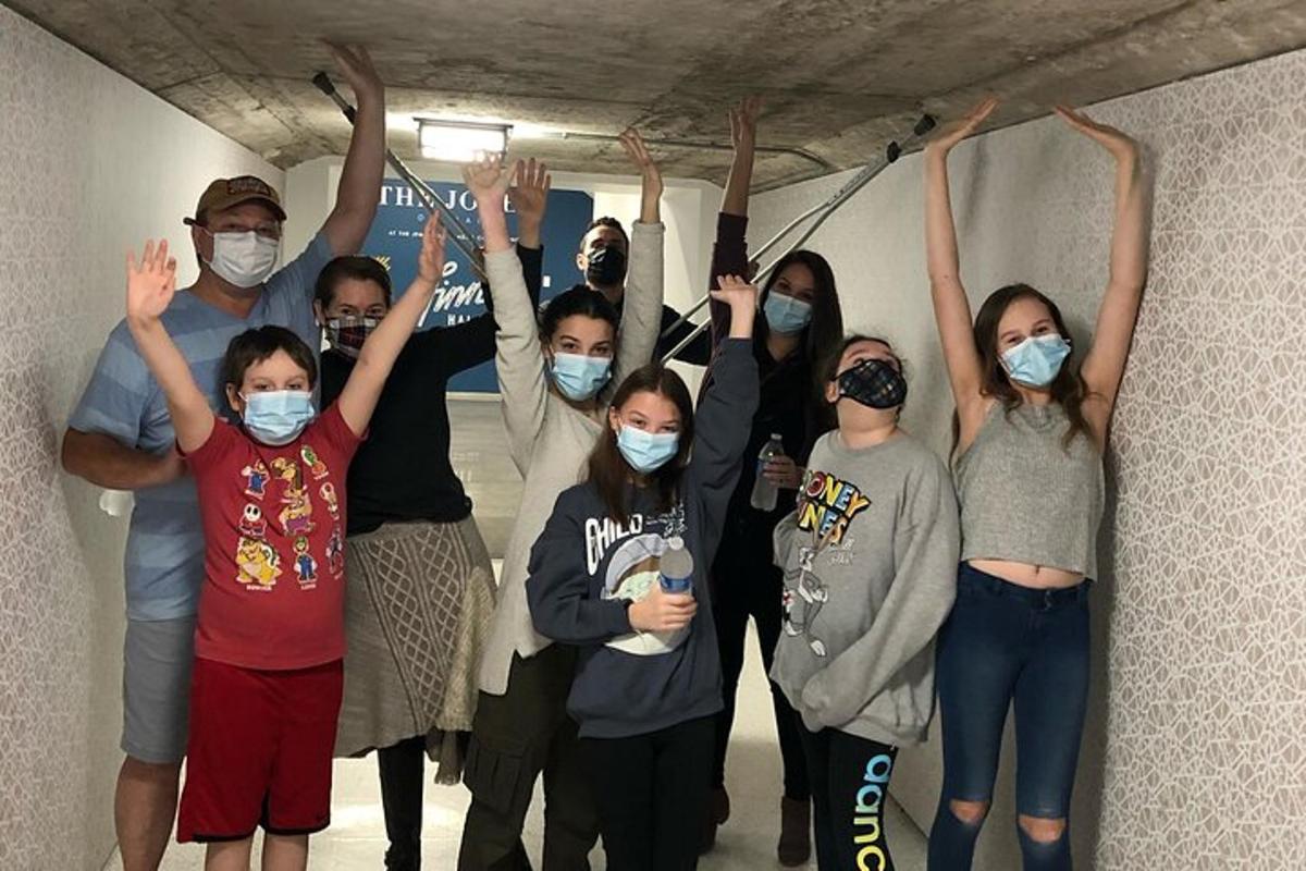 a group of people standing in a room with their hands in the air