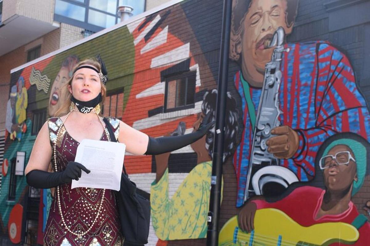 seorang wanita berdiri di hadapan mural