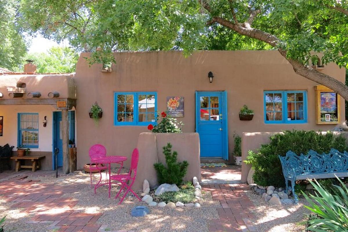 a house with a blue door and pink chairs