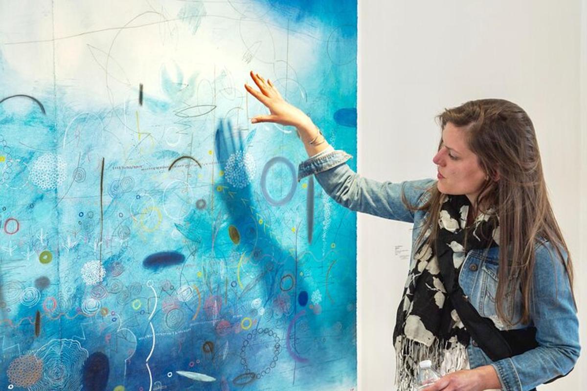 a woman is standing in front of a painting