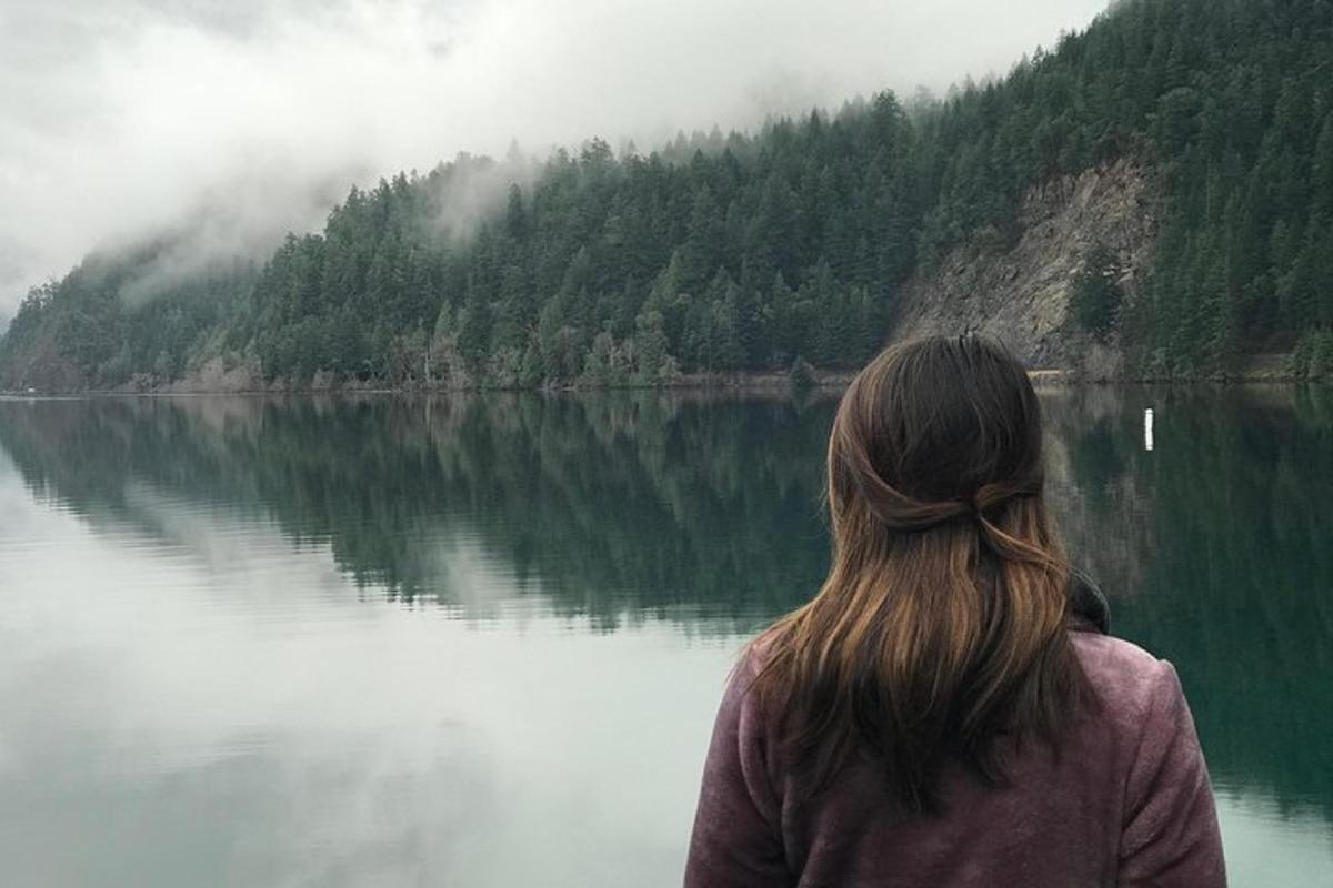 a woman standing in front of a body of water