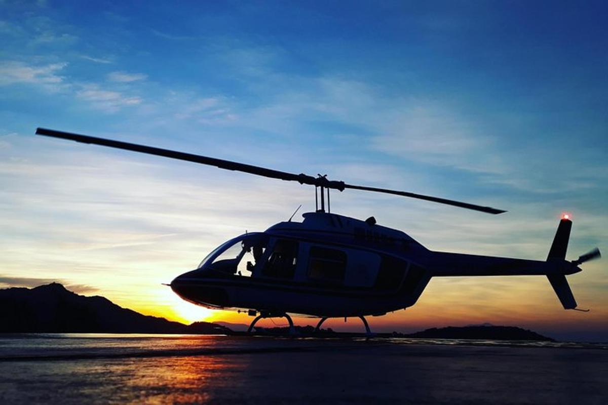 a helicopter parked on a runway with the sunset in the background