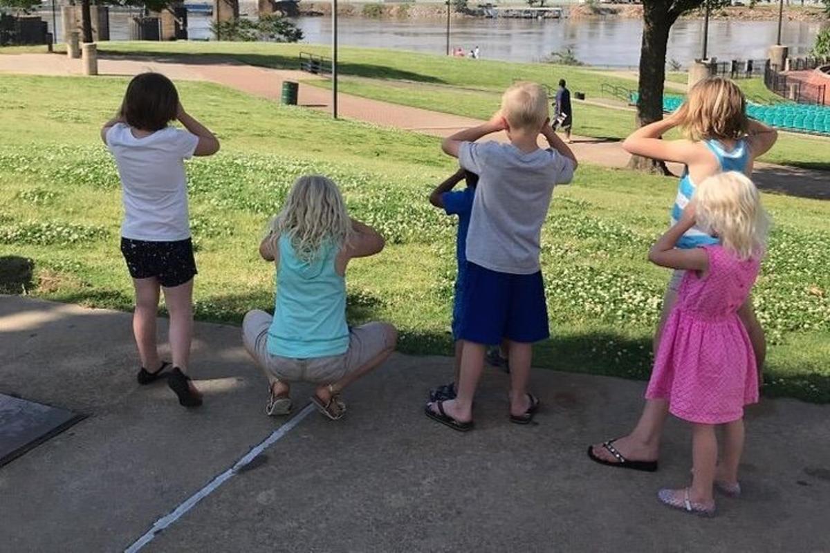 eine Gruppe von Kindern, die in einem Park herumstehen