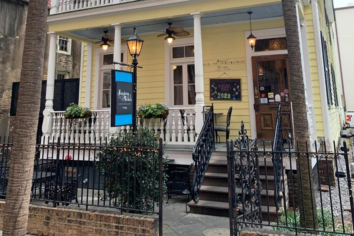 a yellow house with a front porch with a gate
