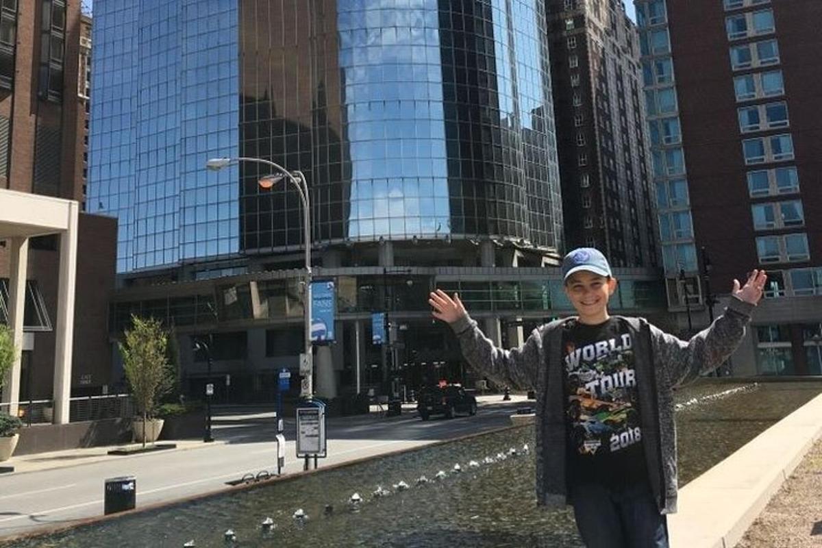 seorang lelaki berdiri di sebuah bandar dengan tangan dihulurkan