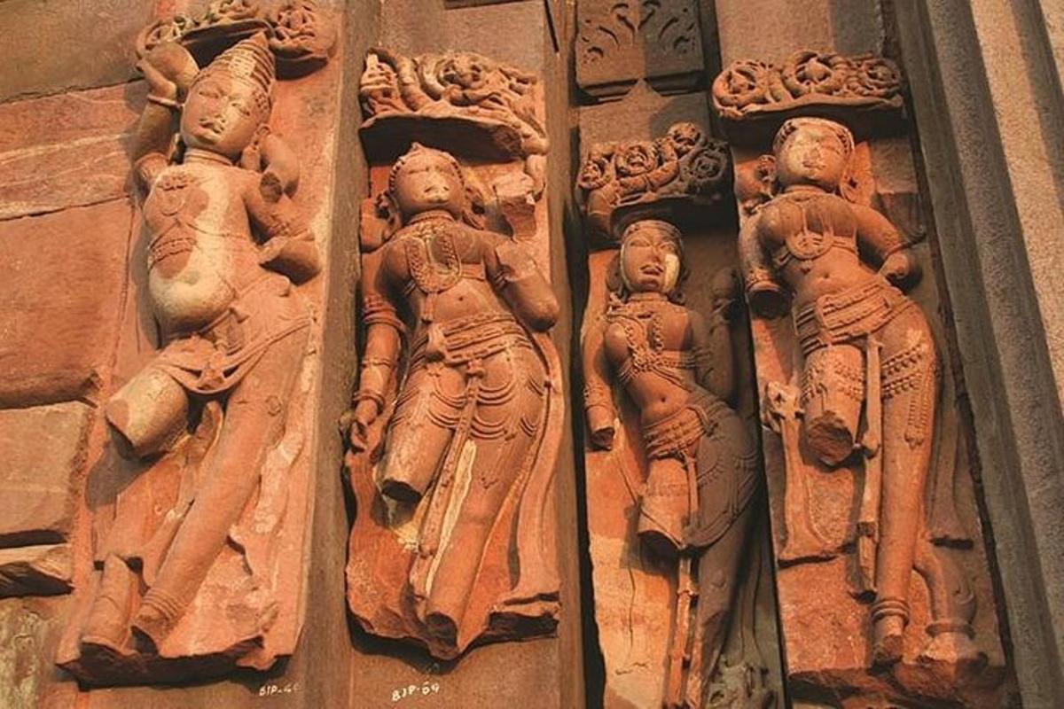 a stone wall with statues of people on it
