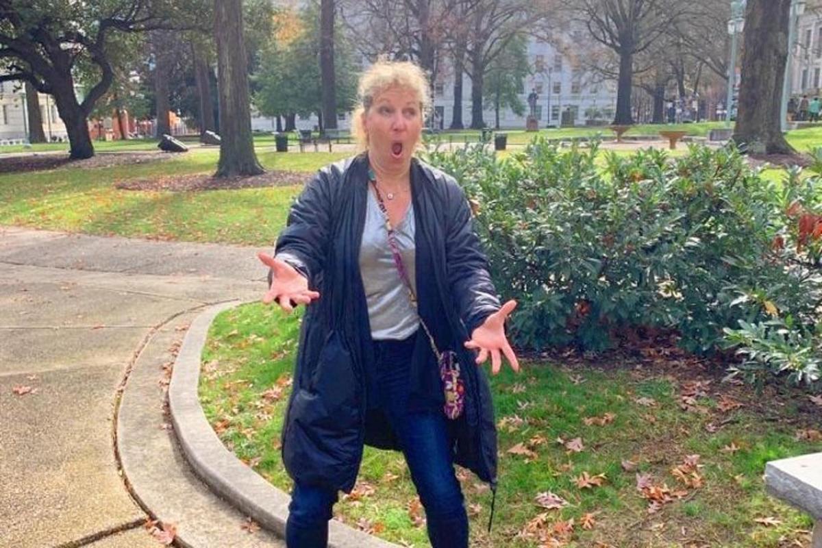 an older woman is walking in a park