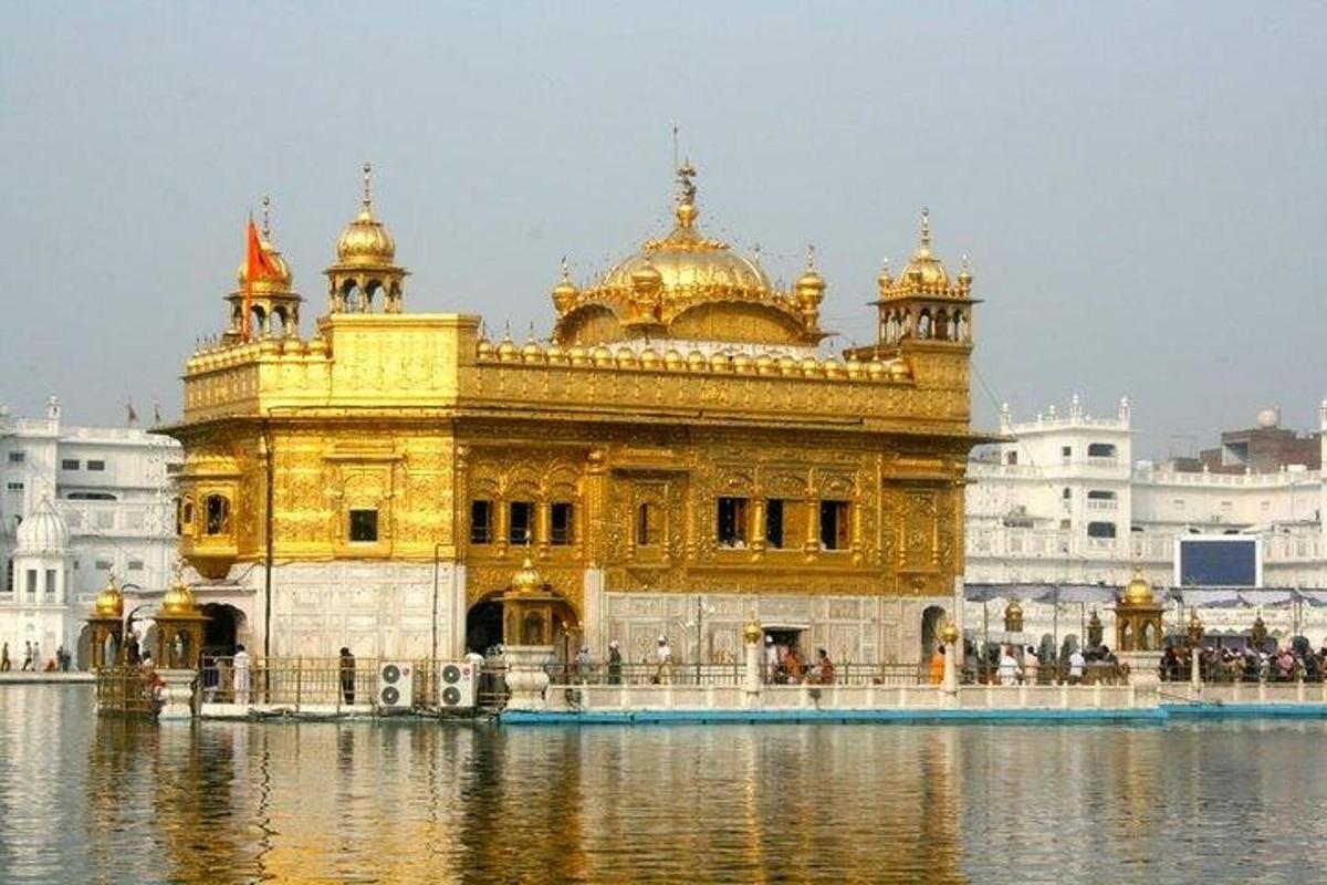 a golden temple with water in front of it