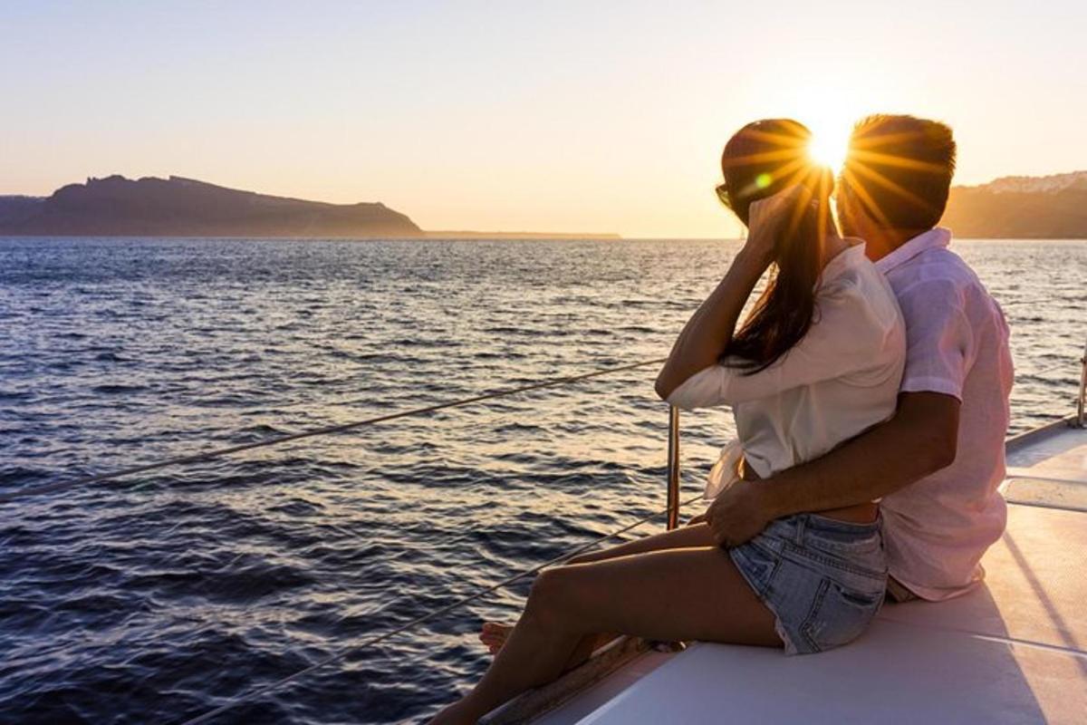a couple sitting on a boat watching the sunset